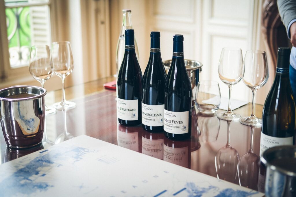 Burgundy red wine bottles and glasses arranged on a tasting table in Beaune, France