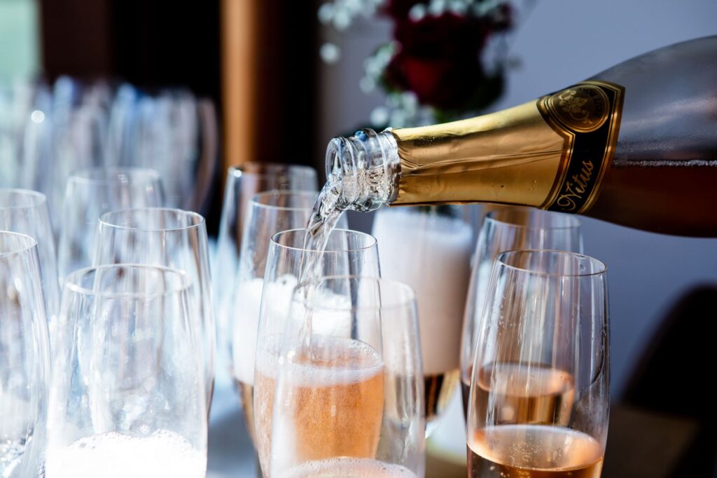Champagne being poured into flute glasses at a celebration, showing the bubbles and golden color